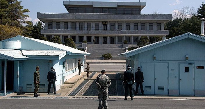 A view from South Korea towards North Korea in the Joint Security Area at Panmunjom. North and South Korean military personnel, as well as a single US soldier, are shown