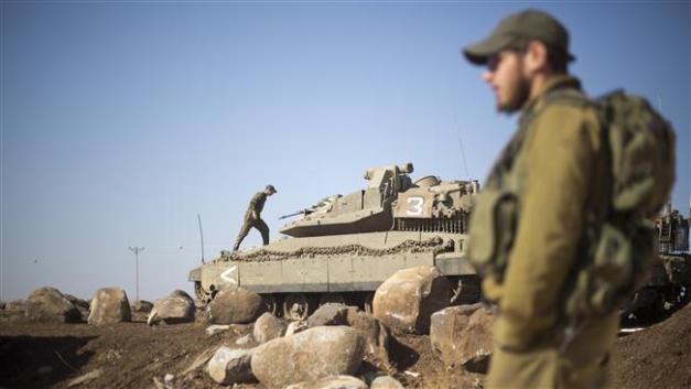 Israeli soldiers gather next to their tanks near the Syrian border in the occupied Golan Heights, November 28, 2016. (Photo by AP)