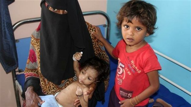 A Yemeni woman sits with one of her children as she carries another malnourished one at a hospital in Khokha, near Yemen's flash-point port city of Hudaydah, January 21, 2019. (Photo by AFP)